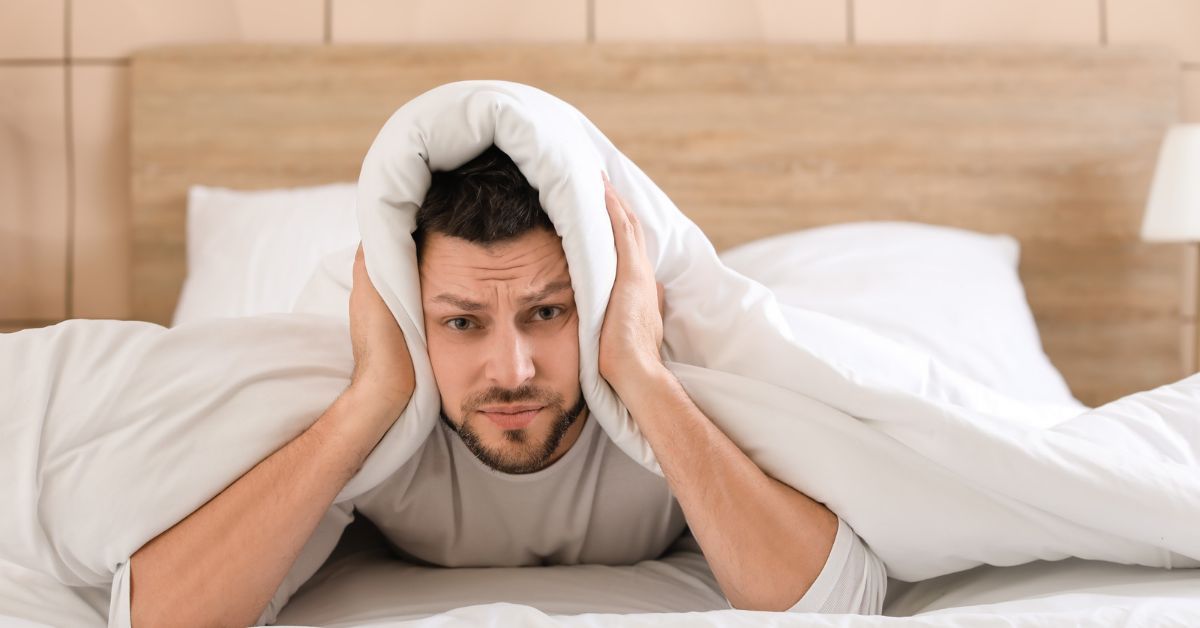 Uomo che si copre la testa con la coperta