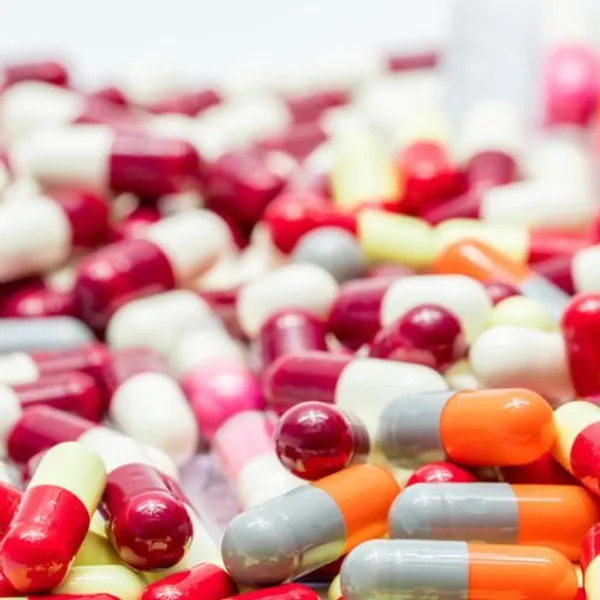 Massa sfocata di capsule e pillole medicinali colorate in primo piano