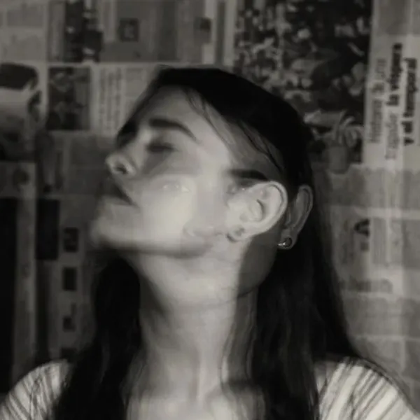 Delirio - ragazza con occhi chiusi su sfondo di giornali