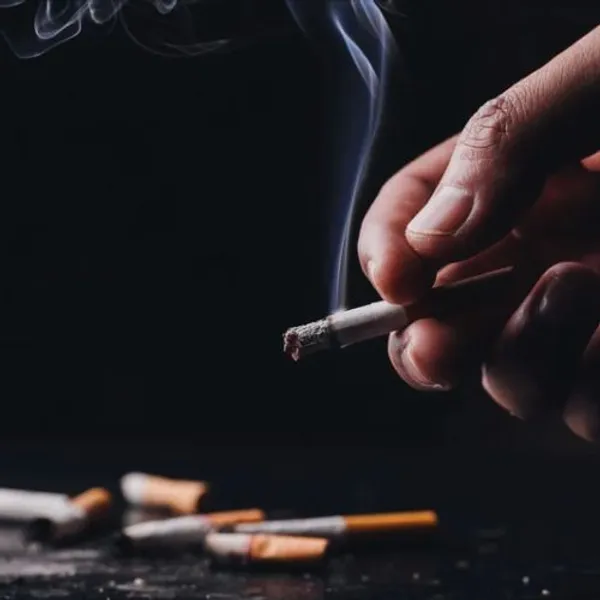 Tabagismo - mano che tiene una sigaretta che fuma