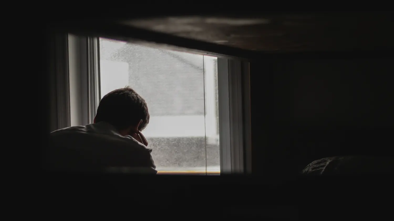 Uomo depresso con finestra sullo sfondo