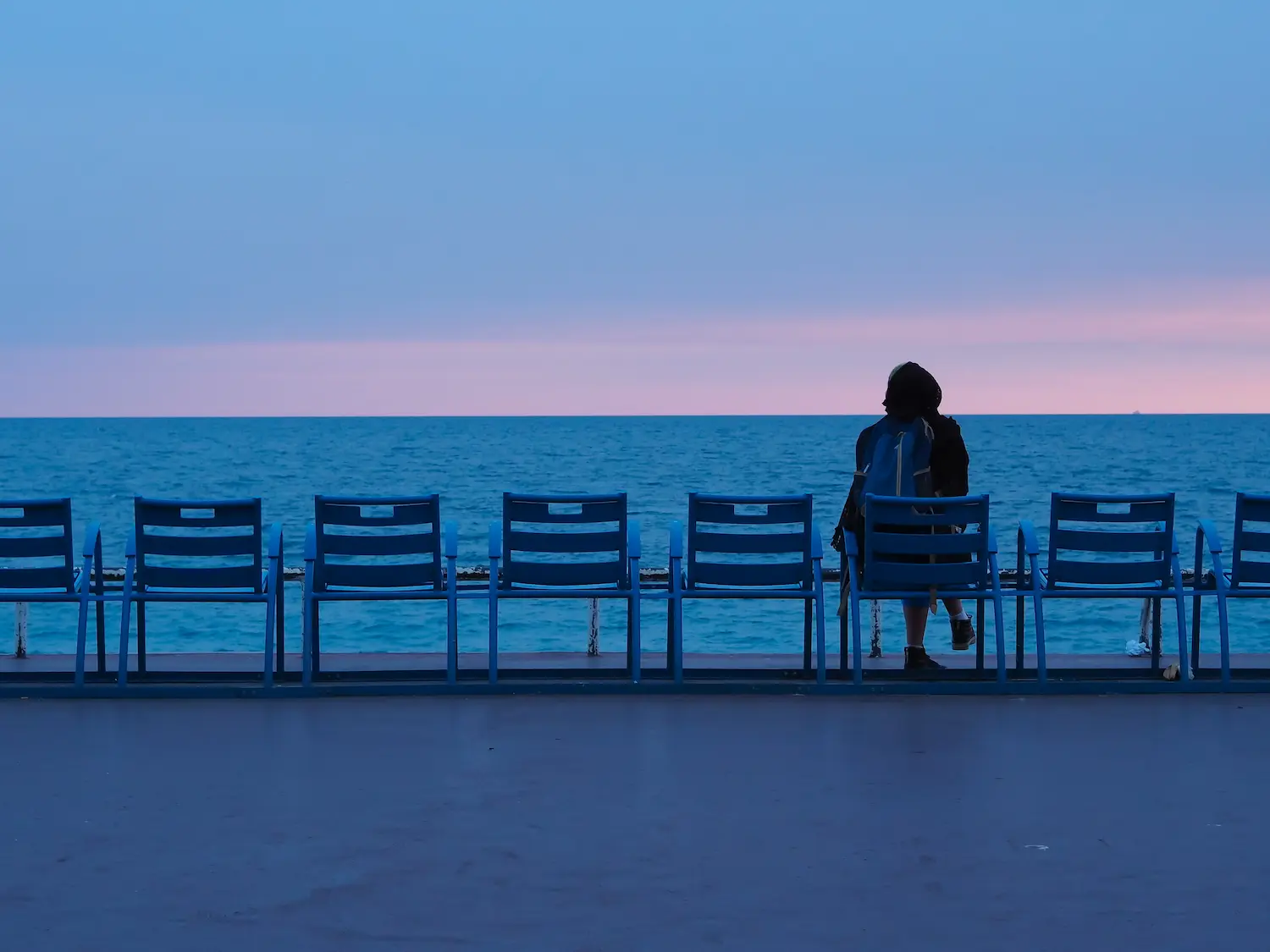 Donna seduta che guarda il mare in solitudine
